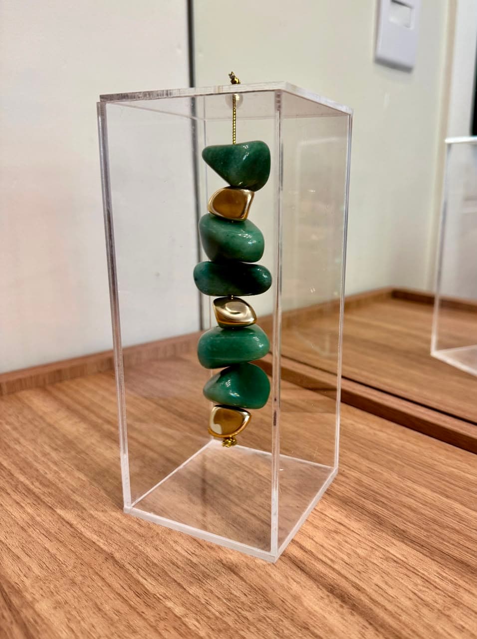 Escultura com pedras naturais roladas em estrutura de acrílico, da linha 03 da Deliluz Decor